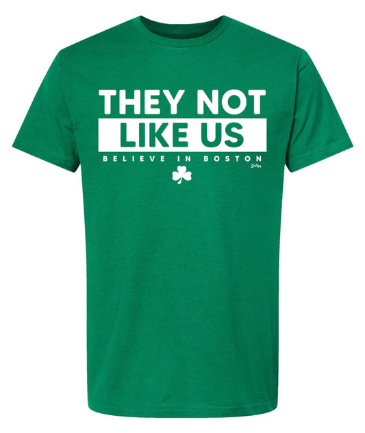 Green T-shirt that says "They Not Like US Believe in Boston" In white font. 